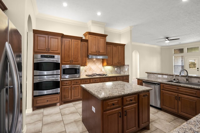 226 Beasley Reef Dr, Beach City, TX 77523 - kitchen with stainless steel appliances, a sink, arched walkways, a kitchen island, and a ceiling fan