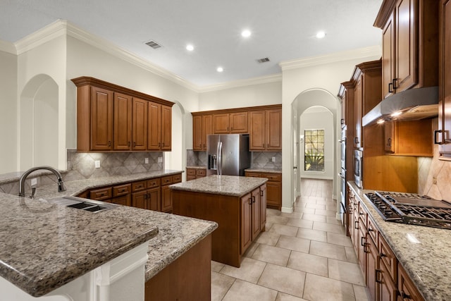 226 Beasley Reef Dr, Beach City, TX 77523 - kitchen featuring stainless steel fridge, arched walkways, light stone countertops, decorative backsplash, and a kitchen island