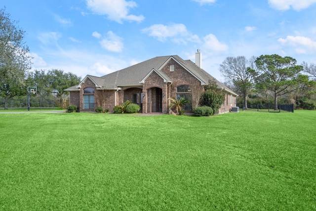226 Beasley Reef Dr, Beach City, TX 77523 - view of front of house featuring brick siding, a chimney, a front lawn, central AC, and a shingled roof
