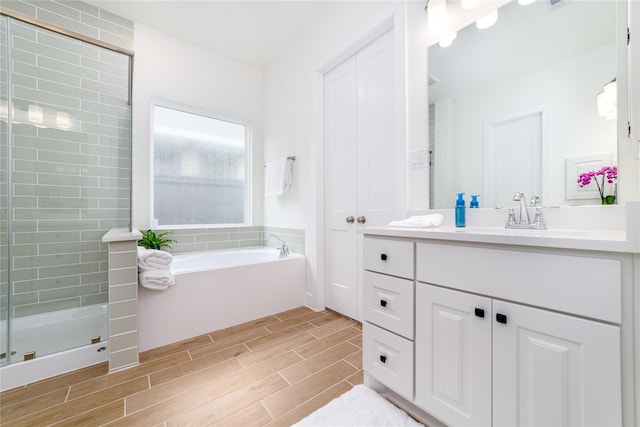 4603 Vaughan Way, Iowa Colony, TX 77583 - bathroom featuring wood finish floors, a bath, a stall shower, and vanity