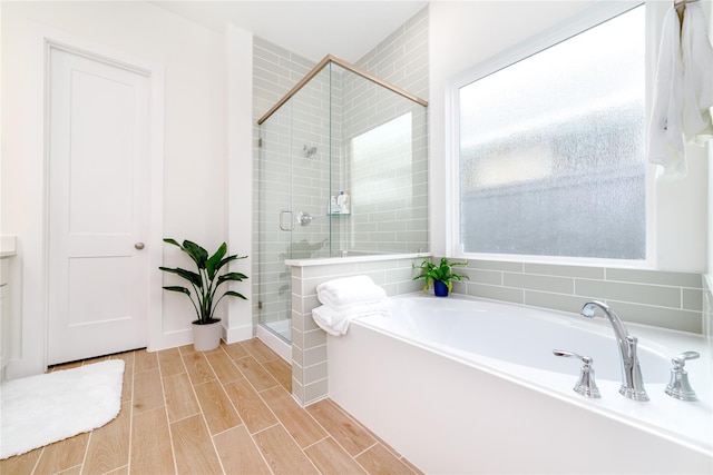 4603 Vaughan Way, Iowa Colony, TX 77583 - full bathroom featuring a stall shower, a garden tub, and wood finish floors