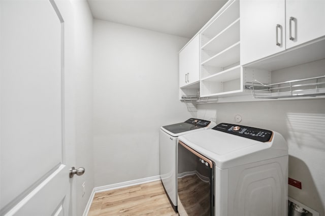 20511 Kendall Cliff Ct, Katy, TX 77449 - clothes washing area with separate washer and dryer, cabinet space, light wood-style floors, baseboards, and arched walkways