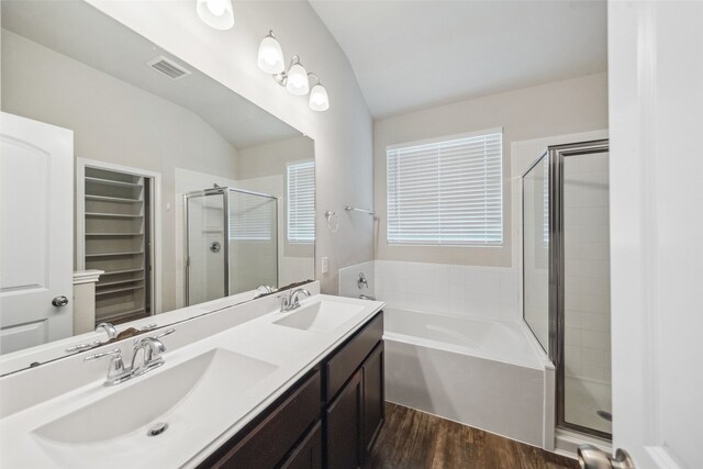 20511 Kendall Cliff Ct, Katy, TX 77449 - full bathroom featuring a shower stall, vaulted ceiling, a garden tub, wood finished floors, and double vanity