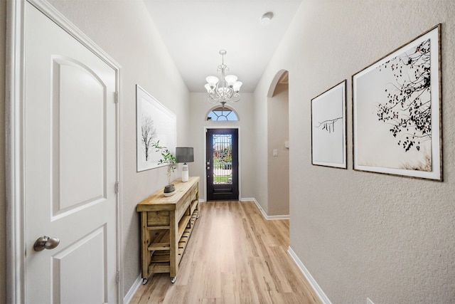 20511 Kendall Cliff Ct, Katy, TX 77449 - entrance foyer featuring arched walkways, light wood finished floors, a chandelier, and baseboards