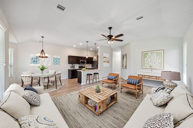 20511 Kendall Cliff Ct, Katy, TX 77449 - living area with vaulted ceiling, light wood-type flooring, a chandelier, a ceiling fan, and baseboards