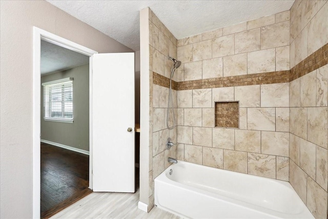 240 Berwick Dr, Bridge City, TX 77611 - full bathroom with  shower combination, wood finished floors, baseboards, and a textured ceiling
