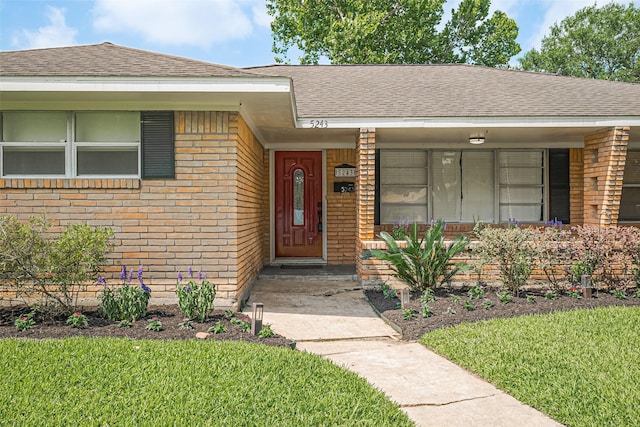 5243 Stillbrooke Dr, Houston, TX 77096 - property entrance with brick siding, roof with shingles, and a lawn