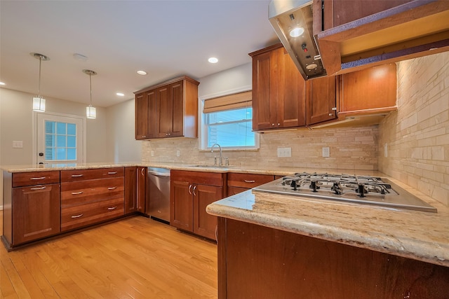 5243 Stillbrooke Dr, Houston, TX 77096 - kitchen with stainless steel appliances, a peninsula, a sink, light wood-style flooring, and tasteful backsplash