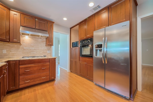 5243 Stillbrooke Dr, Houston, TX 77096 - kitchen featuring stainless steel appliances, under cabinet range hood, light wood-type flooring, tasteful backsplash, and recessed lighting