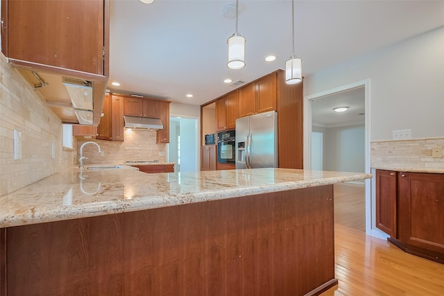 5243 Stillbrooke Dr, Houston, TX 77096 - kitchen with under cabinet range hood, stainless steel appliances, decorative backsplash, a sink, and light wood-style flooring