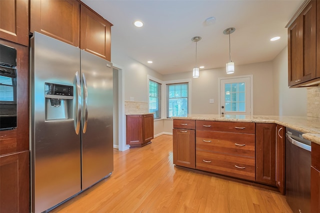 5243 Stillbrooke Dr, Houston, TX 77096 - kitchen with stainless steel appliances, light wood-style floors, a peninsula, light stone countertops, and hanging light fixtures