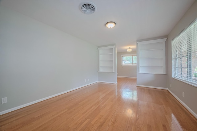 5243 Stillbrooke Dr, Houston, TX 77096 - unfurnished room with light wood finished floors, built in shelves, and baseboards