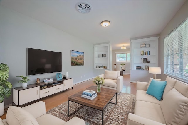 5243 Stillbrooke Dr, Houston, TX 77096 - living area with light wood-style flooring, baseboards, and built in shelves