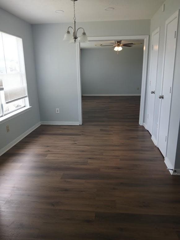 13523 La Concha Ln, Houston, TX 77083 - unfurnished dining area featuring dark wood-type flooring, a chandelier, baseboards, and ceiling fan