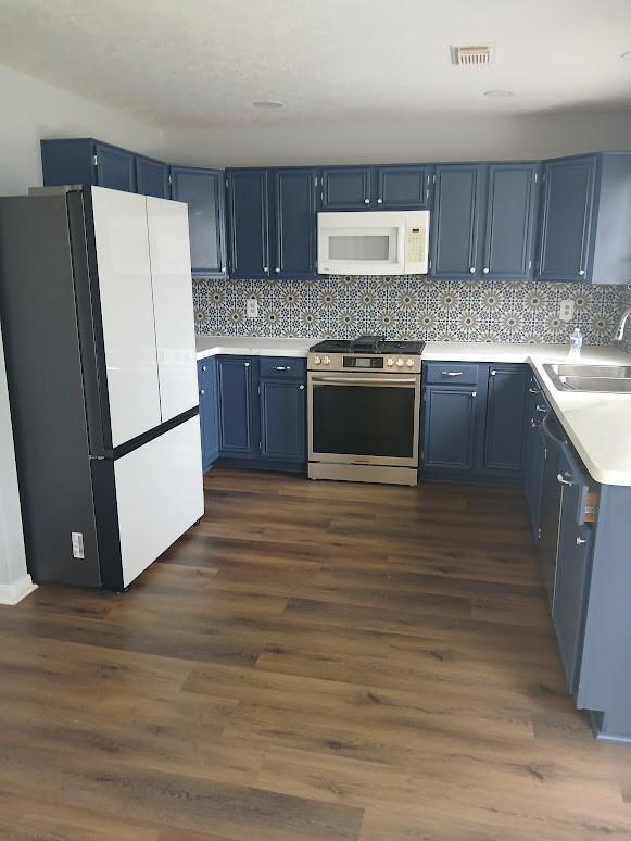 13523 La Concha Ln, Houston, TX 77083 - kitchen featuring white appliances, a sink, blue cabinetry, and light countertops