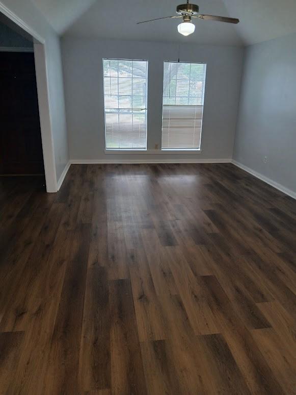 13523 La Concha Ln, Houston, TX 77083 - spare room with a ceiling fan, baseboards, vaulted ceiling, and dark wood-style flooring
