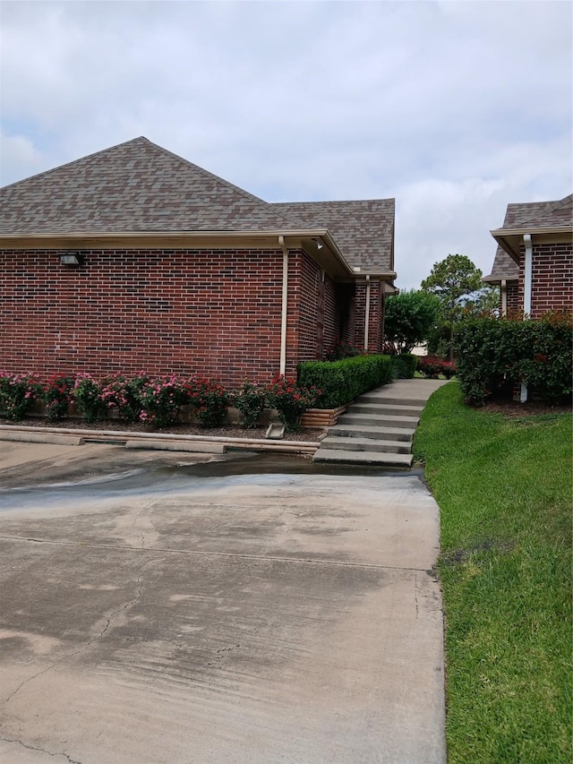 13523 La Concha Ln, Houston, TX 77083 - view of property exterior with brick siding, a shingled roof, and a yard