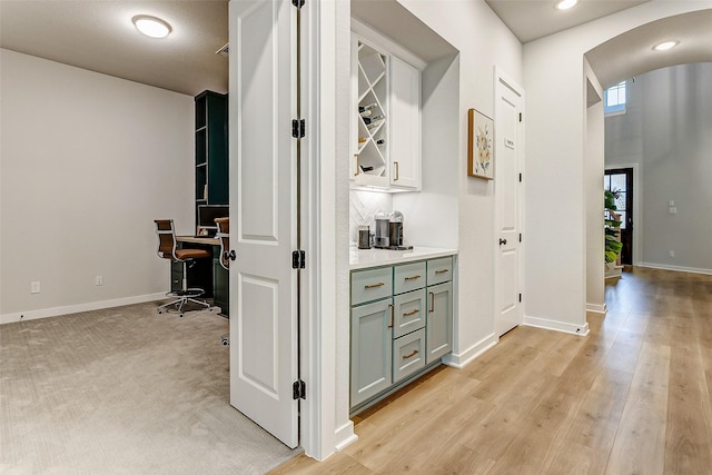 24910 Hibiscus Garden Way, Katy, TX 77493 - hall with arched walkways, a desk, baseboards, light wood-style flooring, and recessed lighting
