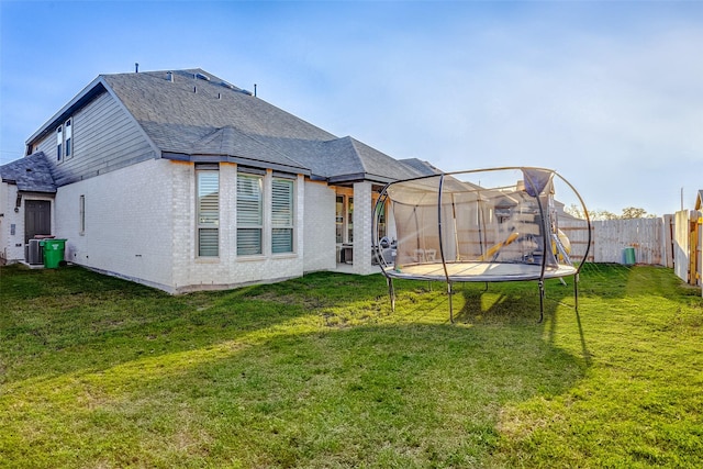 24910 Hibiscus Garden Way, Katy, TX 77493 - rear view of property featuring a trampoline, roof with shingles, and brick siding