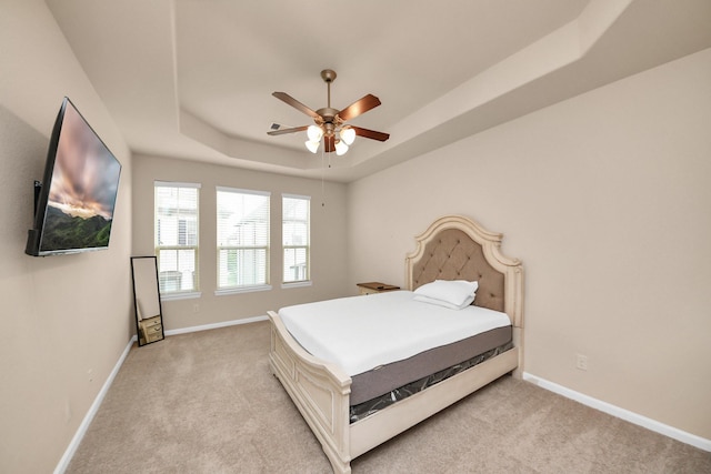 10805 N Kyler Oaks Pl, Houston, TX 77043 - bedroom with a raised ceiling, light carpet, baseboards, and ceiling fan