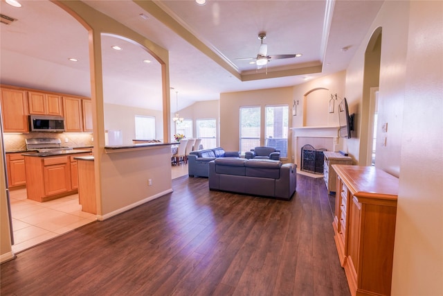 5910 Hatfield Glen Dr, Katy, TX 77449 - living room featuring a ceiling fan, arched walkways, wood finished floors, a tray ceiling, and recessed lighting