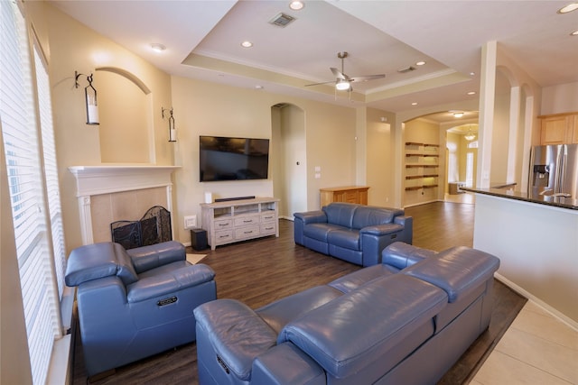 5910 Hatfield Glen Dr, Katy, TX 77449 - living room featuring arched walkways, ceiling fan, a raised ceiling, wood finished floors, and recessed lighting