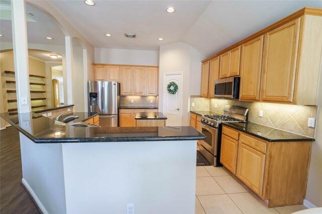 5910 Hatfield Glen Dr, Katy, TX 77449 - kitchen featuring stainless steel appliances, arched walkways, a center island, decorative backsplash, and recessed lighting