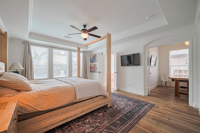 8113 Tranquil Lake Way, Conroe, TX 77385 - bedroom with a tray ceiling, wood finished floors, crown molding, baseboards, and a ceiling fan