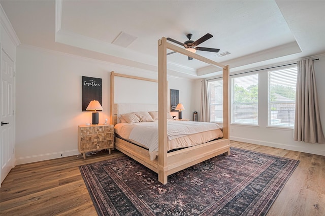 8113 Tranquil Lake Way, Conroe, TX 77385 - bedroom with a tray ceiling, wood finished floors, crown molding, baseboards, and ceiling fan