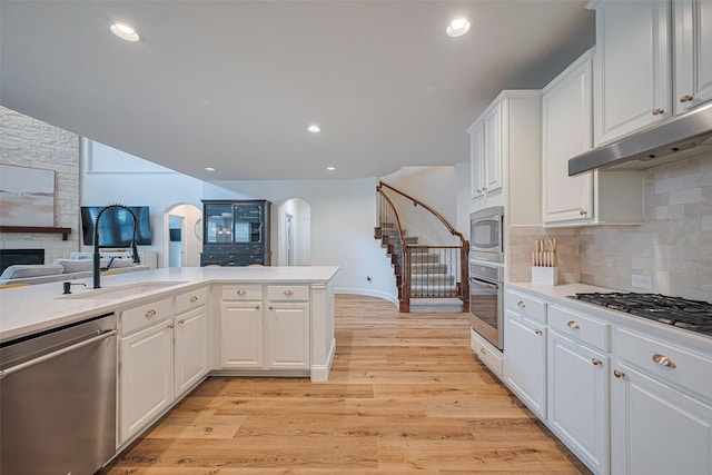8113 Tranquil Lake Way, Conroe, TX 77385 - kitchen featuring appliances with stainless steel finishes, arched walkways, a sink, light countertops, and recessed lighting