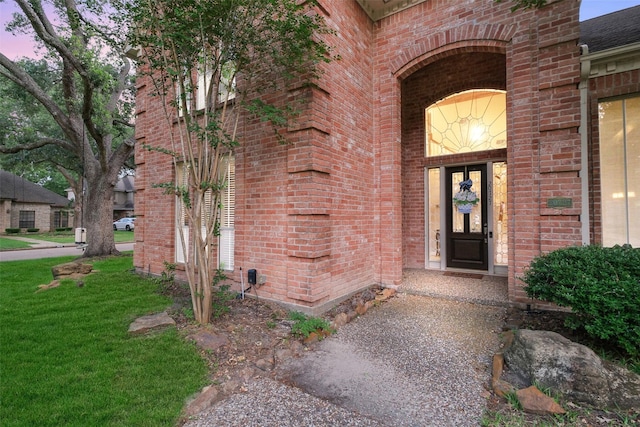 20727 Sea Pine Dr, Katy, TX 77450 - exterior entry at dusk featuring brick siding and a lawn