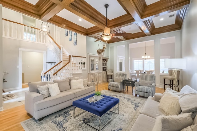 20727 Sea Pine Dr, Katy, TX 77450 - living room featuring a chandelier, coffered ceiling, stairway, beamed ceiling, and light wood-type flooring