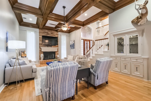 20727 Sea Pine Dr, Katy, TX 77450 - living room featuring light wood finished floors, coffered ceiling, stairway, a fireplace, and beam ceiling