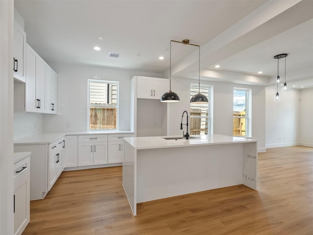 2207 Dan St, Houston, TX 77020 - kitchen featuring healthy amount of natural light, light wood finished floors, recessed lighting, white cabinetry, and pendant lighting