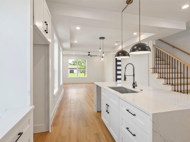 2207 Dan St, Houston, TX 77020 - kitchen with light wood finished floors, white cabinetry, recessed lighting, ceiling fan, and decorative light fixtures