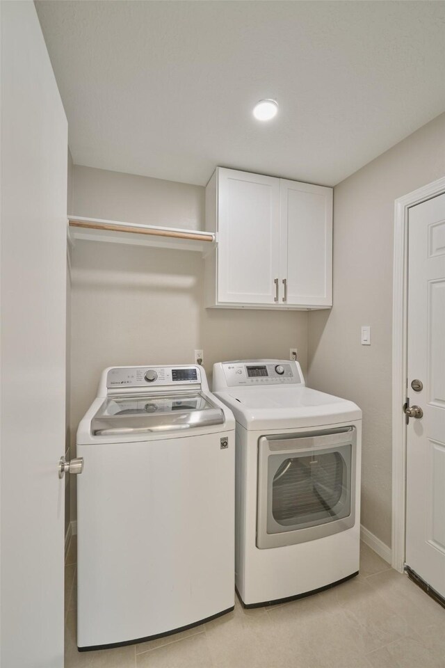 60 Hickory Oak Dr, The Woodlands, TX 77381 - laundry area with washer and clothes dryer, cabinet space, and baseboards