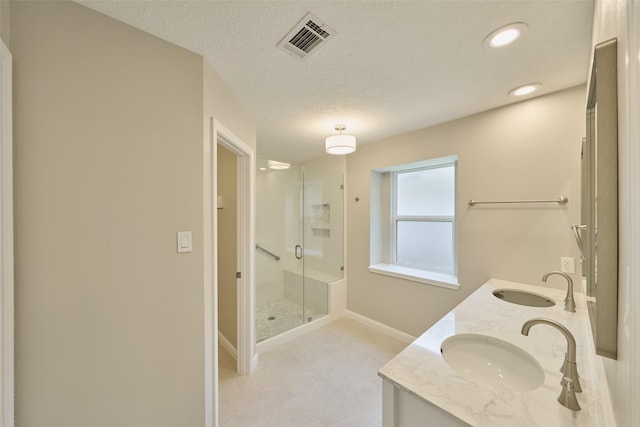 60 Hickory Oak Dr, The Woodlands, TX 77381 - bathroom with a stall shower, double vanity, baseboards, a textured ceiling, and recessed lighting