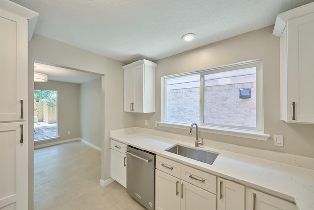 60 Hickory Oak Dr, The Woodlands, TX 77381 - kitchen with stainless steel dishwasher, a sink, white cabinetry, light countertops, and a textured ceiling