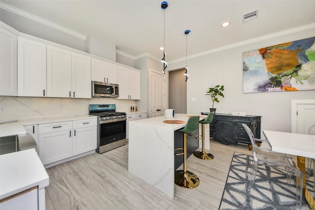 3033 Dennis St, Houston, TX 77004 - kitchen featuring stainless steel appliances, a kitchen breakfast bar, crown molding, white cabinetry, and recessed lighting