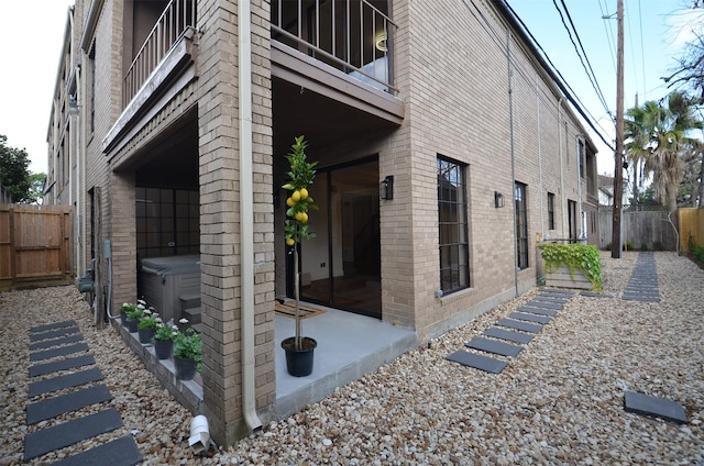 1425 Nantucket Dr Unit D, Houston, TX 77057 - view of side of home with a hot tub, a balcony, brick siding, and a patio area