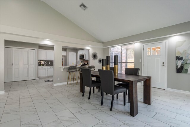 2720 Hot Springs Dr, Pearland, TX 77584 - dining room featuring light marble finish floors, vaulted ceiling, and baseboards