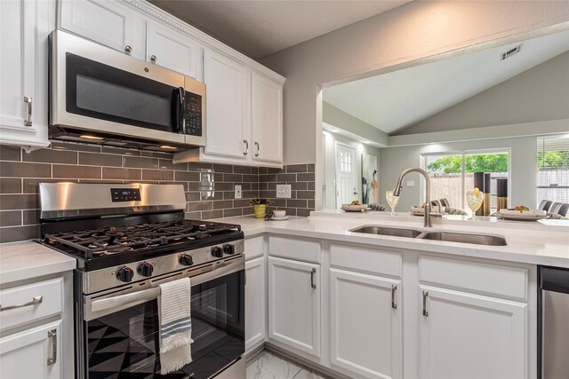 2720 Hot Springs Dr, Pearland, TX 77584 - kitchen with appliances with stainless steel finishes, a sink, lofted ceiling, tasteful backsplash, and white cabinets