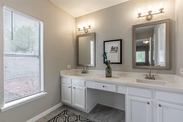 2720 Hot Springs Dr, Pearland, TX 77584 - full bath featuring double vanity, a textured wall, and baseboards