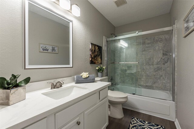 2720 Hot Springs Dr, Pearland, TX 77584 - full bathroom featuring wood finished floors, a textured wall, toilet, enclosed tub / shower combo, and vanity