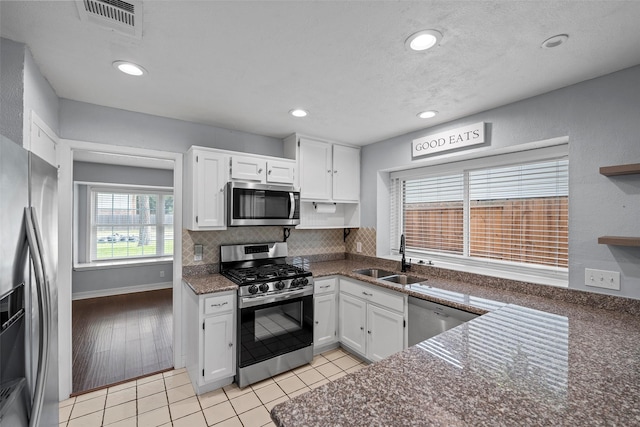 7611 Creekfield Dr, Spring, TX 77379 - kitchen featuring appliances with stainless steel finishes, a sink, white cabinetry, tasteful backsplash, and recessed lighting
