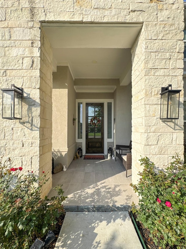 doorway to property with stucco siding and stone siding