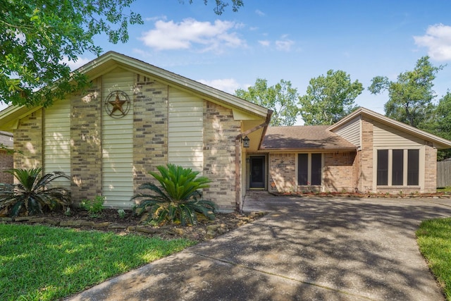 16135 Spinnaker Dr, Crosby, TX 77532 - mid-century home with brick siding, concrete driveway, and roof with shingles