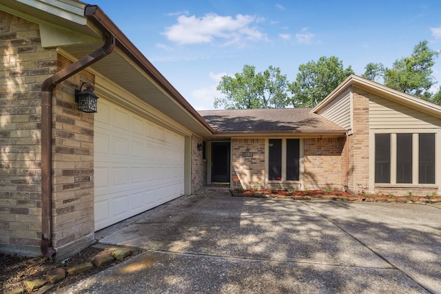 16135 Spinnaker Dr, Crosby, TX 77532 - doorway to property featuring roof with shingles, a garage, brick siding, and driveway