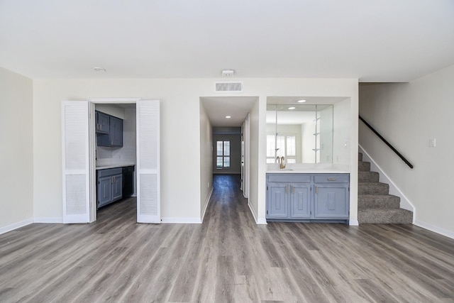 10378 Briar Forest Dr Unit 32/5, Houston, TX 77042 - unfurnished living room with light wood-type flooring, a sink, baseboards, stairs, and recessed lighting