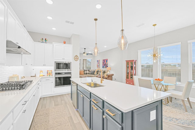 10702 Pleasant View Dr, Missouri City, TX 77459 - kitchen with appliances with stainless steel finishes, a sink, under cabinet range hood, gray cabinets, and white cabinetry